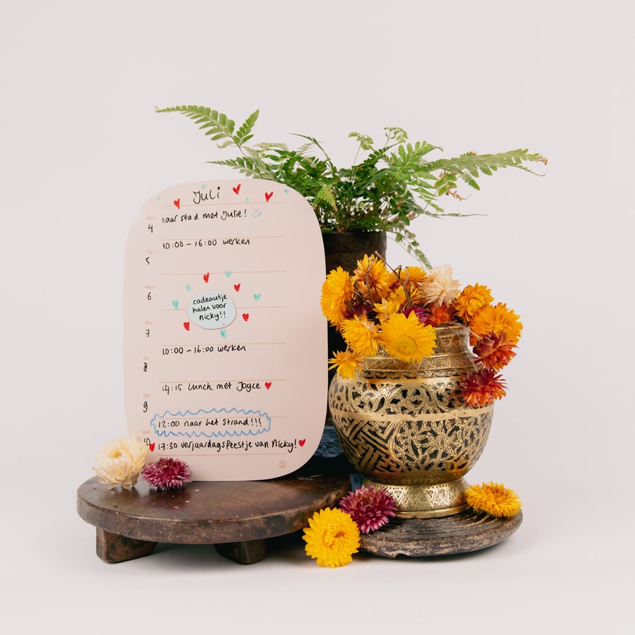 Sticky Wochenplaner auf einem Altar mit Trockenblumen.