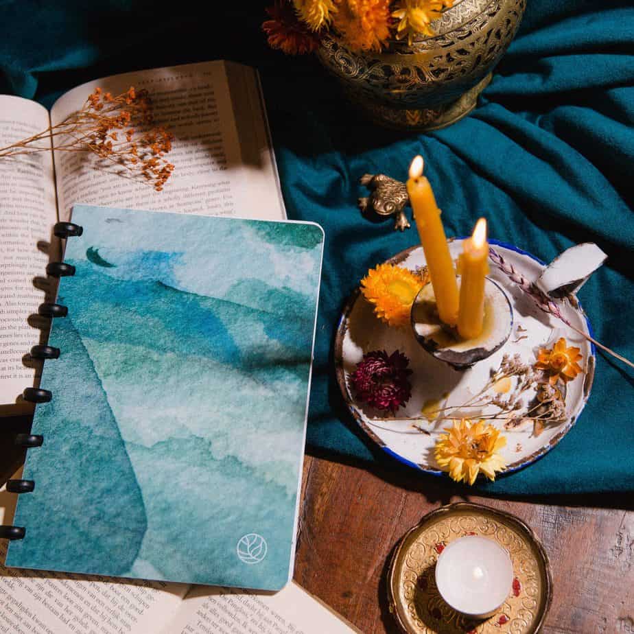 ein Whiteboard-Notizbuch mit Bordeira-Strandumschlag, flach auf einem Holztisch mit Zubehör für das Stimmungsbild
