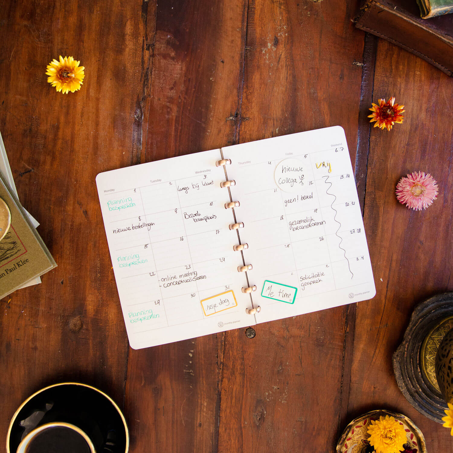 ein Whiteboard-Notizbuch auf einem Holztisch mit löschbaren Monatsplanern